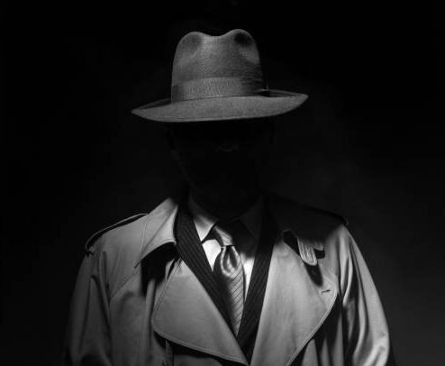 social dectative Man posing in the dark with a fedora hat and a trench coat, 1950s noir film style character